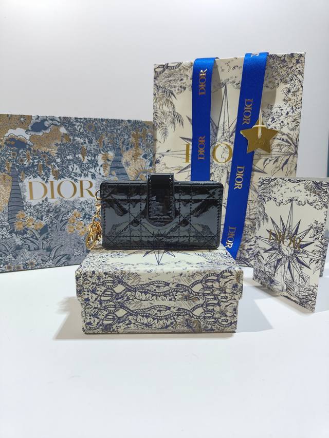 S0074这款 Lady Dior 5 格卡夹饰有经典的藤格纹缉面线 向 Dior 工匠的精湛工艺致敬 采用外面亮漆皮 内裡羊皮精心制作 精巧实用 可收纳各种日