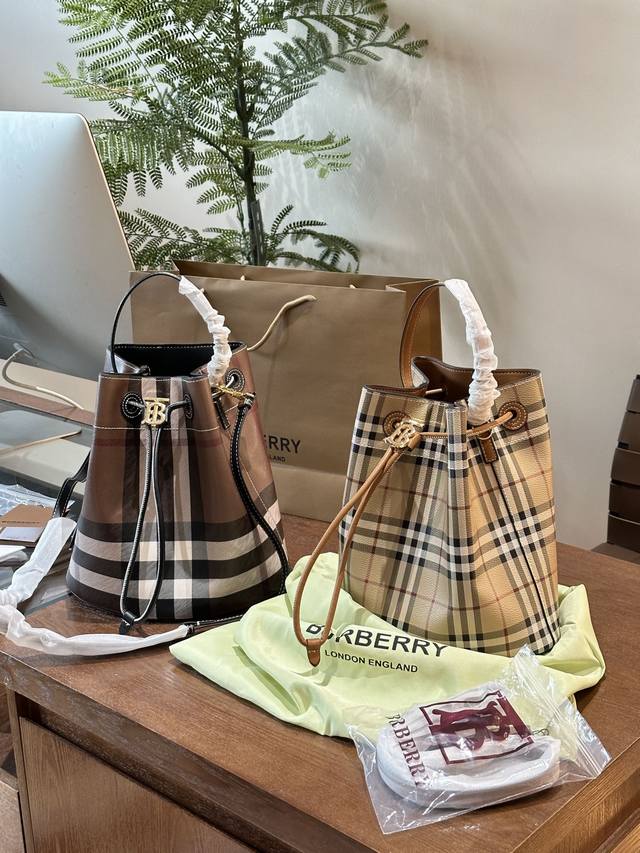 Burberry 水桶 包 灵感来源于中世纪时期的香槟桶抽绳水桶包，装饰Burberry格纹，融入TB专属标识设计。25×30