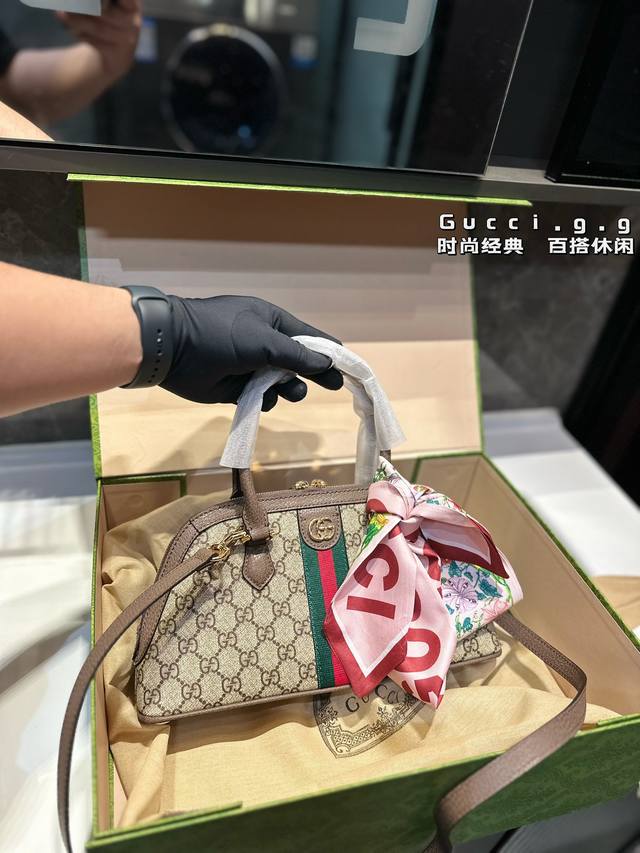 Gucci Ophidia 系列波士顿横版贝壳包包ophidia系列以新意款式献礼早秋系列。这款手提包采用米色和乌木色 Gg Supreme 帆布制作，搭配可拆