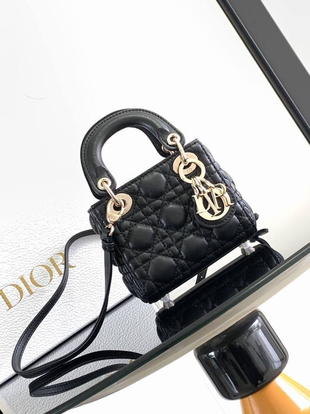 这款 Lady Dior 超迷你手袋集中体现了 Dior 对优雅和美丽的深刻洞见。采用黑色羊皮革精心制作，饰以藤格纹缉面线，搭配 D.I.O.R. 吊饰，为精美 - 点击图像关闭