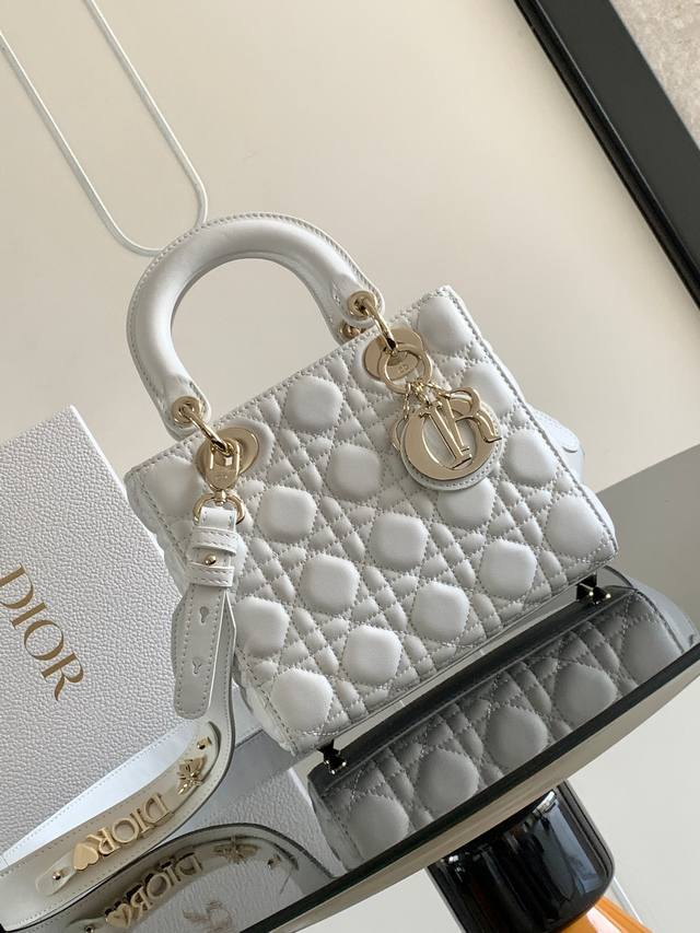 这款四格金扣 Lady Dior Dior 手袋集中体现了 Dior 对优雅和美丽的深刻洞见。采用黑色羊皮革精心制作，以藤格纹缉面线打造醒目的绗缝细节，时髦典雅