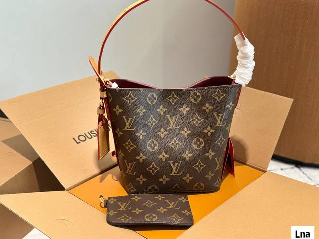 Lv All Inbb手袋为Monogram牛皮搭配亮泽金属件，以标志性挂锁和名牌彰显经典格调。可调节肩带延续品牌制箱传承，皮革肩带增添斜挎和肩背选择。可折叠设